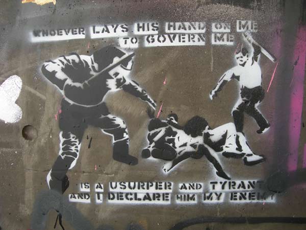 Street art stencil of the riot cops giving some protestors a good kicking